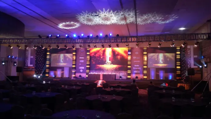 Corporate event stage large LED screen setup formal dining tables